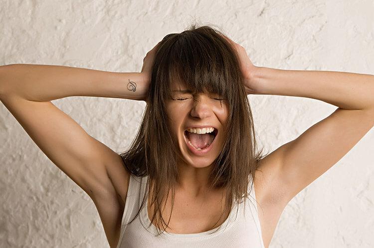 mulher-irritada-maos-cabeca-preocupada-inimigos-cabelo